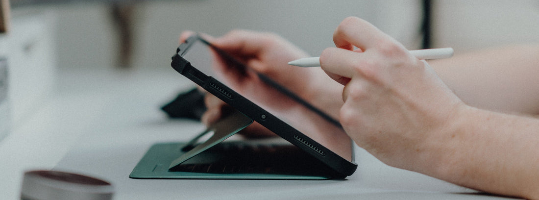 A hand trying to write on an iPad in ZUGU case