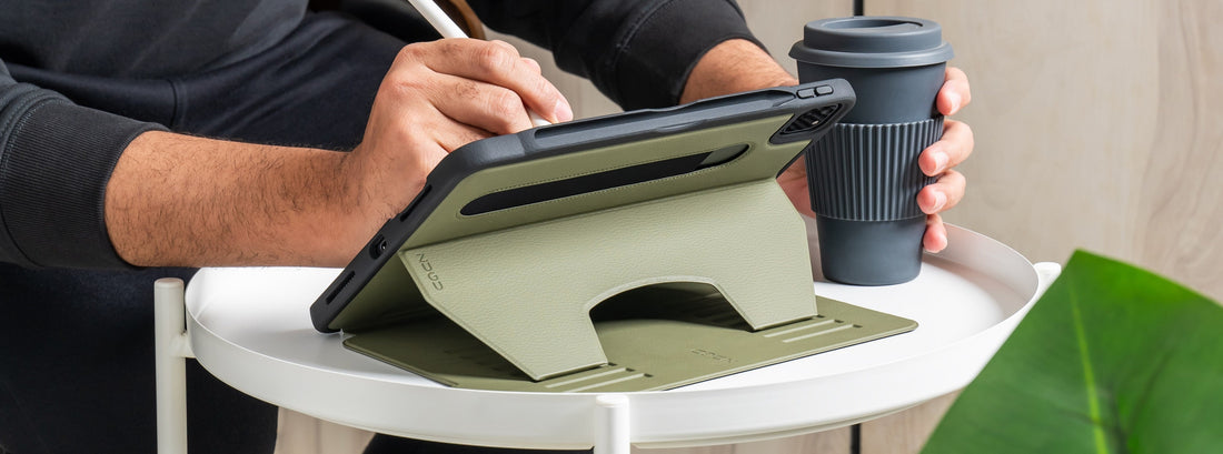 A hand writing on an iPad in ZUGU case