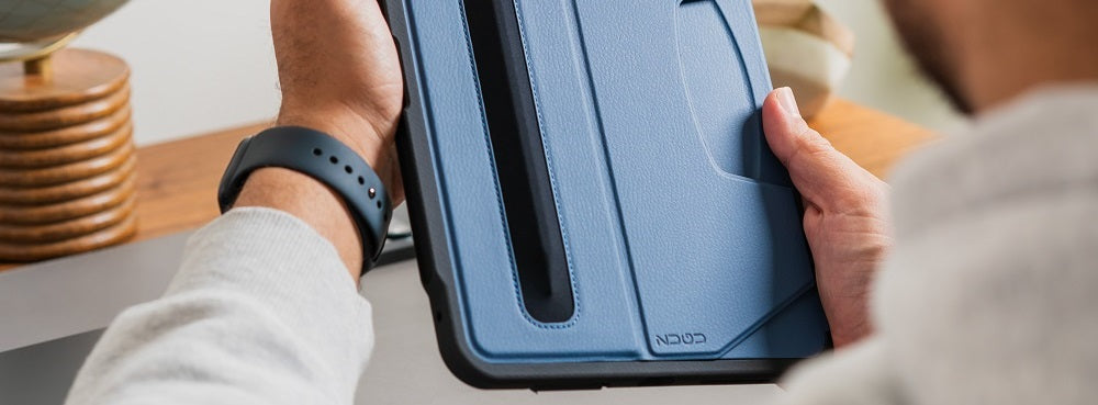 Person holding a blue tablet case with a built-in pen holder.
