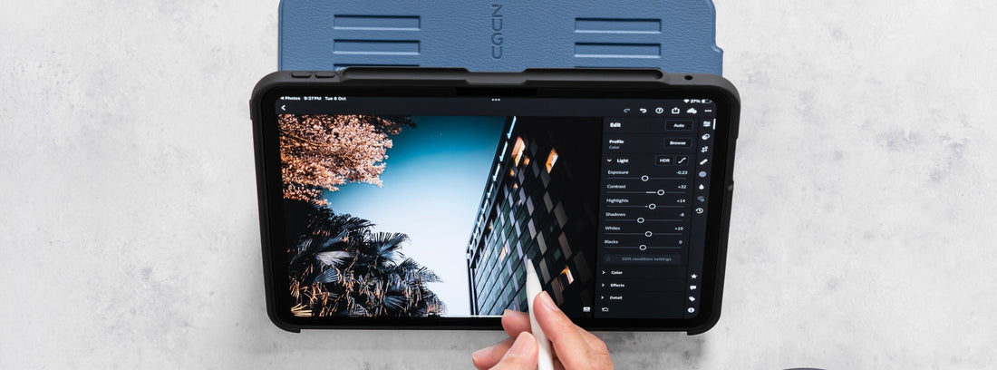 a man’s hand holding an Apple pencil to touch his iPad screen