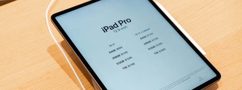 an iPad Pro plugged in to charge with the make and model information on screen