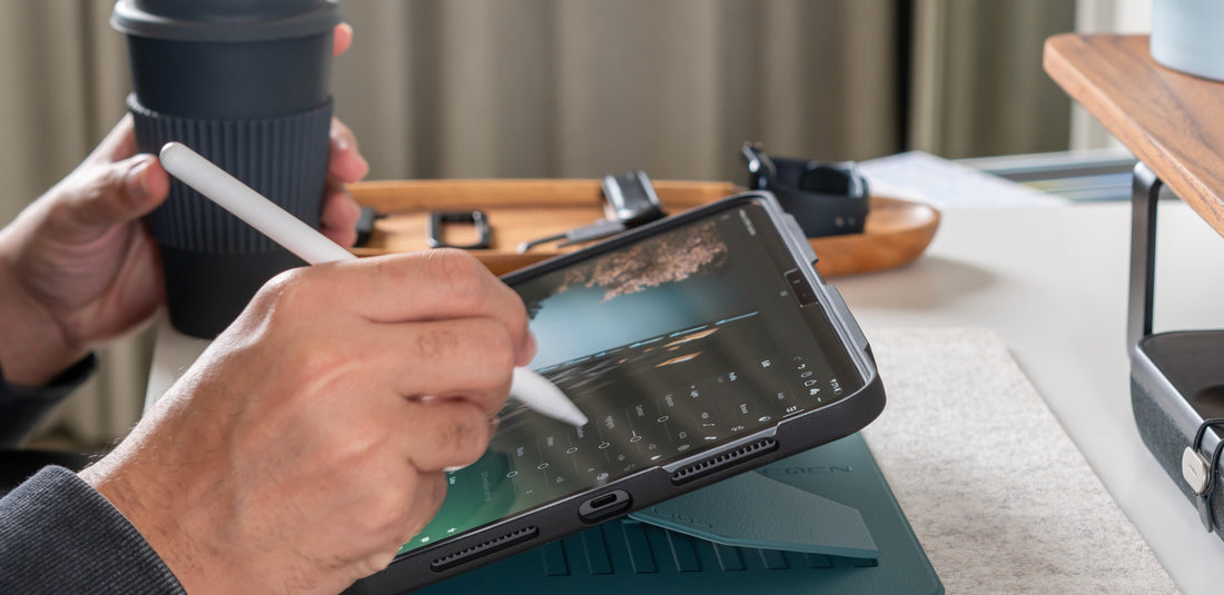 A man using an iPad photo editing app with an Apple Pencil in his right hand, a coffee cup in his left hand. The iPad is in a ZUGU case. 