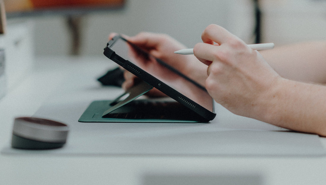 An iPad housed in a Pine ZUGU case being used at a desk with an Apple Pencil