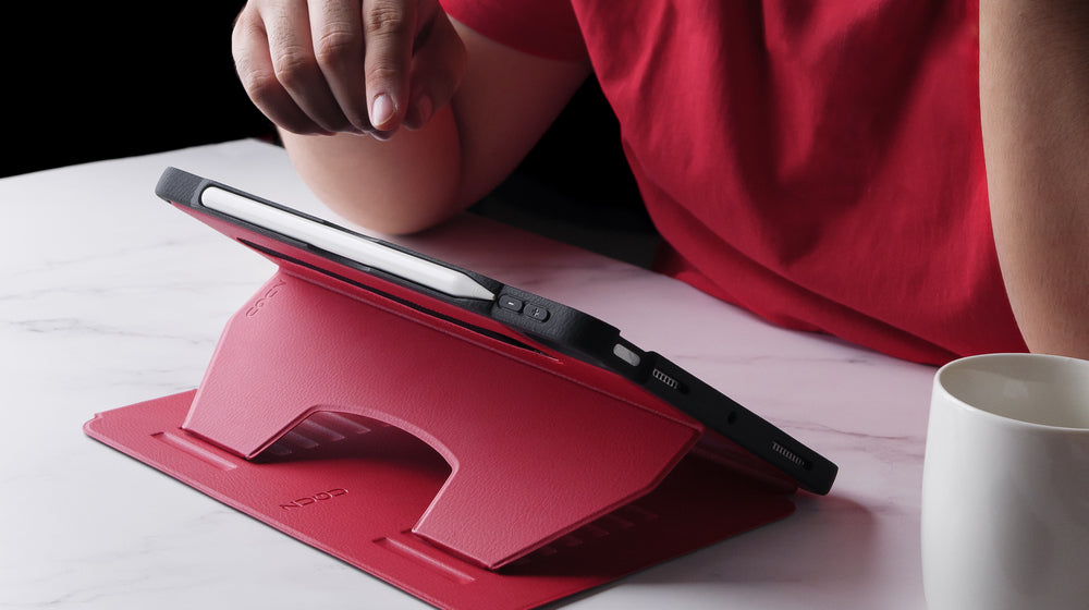 Person using an iPad in a scarlet red ZUGU case, highlighting adjustable viewing angles for comfortable everyday use. 